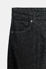 Jeans de tiro alto con corte tapered y largo al tobillo. Presenta cinco bolsillos, trabillas en la cintura, cierre frontal con cremallera y botón, y detalle de raya planchada en el delantero.