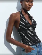 Top negro con cuello halter y apliques de tachas plateadas.