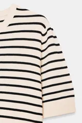 Jersey de punto de manga corta con cuello redondo, a rayas horizontales blancas y negras.