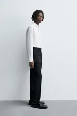 Pantalón de traje regular fit confeccionado en tejido de lana. Presenta bolsillos frontales, bolsillos traseros de vivo con botón y cierre frontal con cremallera y botón.