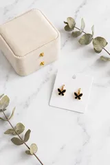 Caravana de acero con diseño de mariposa en color negro con borde dorado.