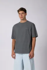 Remera de algodón gris oscuro con efecto lavado, de manga corta y cuello redondo, con pequeño texto bordado en el pecho.