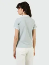 Remera polo celeste de algodón piqué, con cuello clásico y tapeta de dos botones. Tiene mangas cortas con ribete a tono y logo de la marca bordado en el pecho.