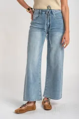 Jean wide leg de tiro medio en color celeste claro, con lavado clásico y cordón ajustable en la cintura.