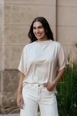 Blusa de calce holgado con escote bote y mangas cortas amplias. Confeccionada en tela liviana con caída fluida.