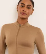 Campera deportiva Get Over de corte ajustado, color marrón, confeccionada en poliamida y elastano con textura acanalada, cuello alto y cierre frontal por cremallera.