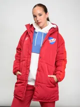 Parka larga de abrigo Umbro del Club Nacional de Football, color rojo con detalles en naranja en las mangas. Cuenta con capucha, cierre frontal con botones a presión y escudo del club bordado en el pecho.