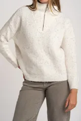 Sweater de punto texturado en color beige melange con motas de colores, diseño oversize, cuello alto con cierre frontal y mangas largas.