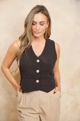 Chaleco negro con escote en V y cierre frontal con tres botones dorados.