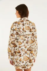 Camisa de manga larga con estampado de hongos en tonos marrones. Tiene cuello clásico, corte recto y abotonadura frontal.