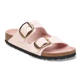 Sandalias Birkenstock modelo Arizona Big Buckle, de color rosado claro con dos tiras anchas ajustables mediante hebillas metálicas grandes de color dorado. Presentan plantilla anatómica forrada en cuero, entresuela de corcho y suela de goma estriada negra.