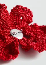 Broche en forma de flor grande realizado en tejido de crochet color rojo, con cierre de gancho en la parte posterior.
