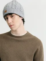 Sweater de punto con textura waffle, color negro, de corte clásico con cuello redondo y mangas largas con puños ajustados.
