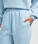 Pantalón jogger de mujer color marrón, confeccionado en algodón y poliéster, con cintura elástica, bolsillos laterales y puños ajustados en los tobillos.