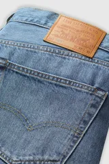 Jeans de corte recto y tiro mid-rise, color azul con lavado medio y efecto ligeramente desgastado, con cierre de botones.