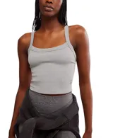 Top deportivo ajustado color gris claro, con escote redondo al frente y espalda cruzada. Presenta un dobladillo recortado que llega por encima de la cintura.