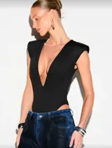 Body negro con escote profundo en V, hombros estructurados y corte high leg. Confeccionado en tela elastizada que se ajusta al cuerpo.