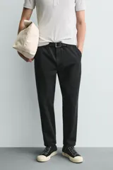 Pantalón de corte carrot fit confeccionado en tejido de algodón con estructura diagonal y efecto lavado. Presenta bolsillos frontales con bolsillo cerillero, bolsillos traseros de plastrón y cierre frontal con cremallera y botón.