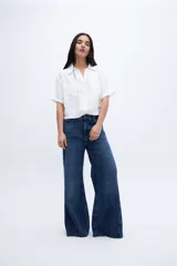 Blusa verde de manga corta con escote en V, cuello camisero y bolsillos en el pecho.