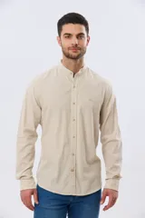 Camisa de lino y algodón color blanco, con cuello mao, manga larga y cierre frontal de botones. Presenta un pequeño logo bordado en el pecho.