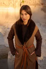 Abrigo largo tipo bata con diseño envolvente y cinturón de cuero. Presenta mangas acolchadas con patrón capitonado, cuerpo de tweed con vivos de cuero y solapa con detalle de corderito.