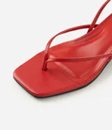 Sandalia de dedo Satinato color rojo, con tiras finas, punta cuadrada, taco bajo tipo kitten heel y tira trasera ajustable con hebilla.