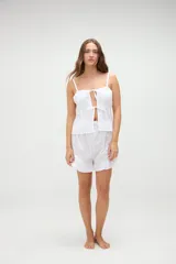 Short de pijama blanco con textura a rayas sutiles, cintura elástica con etiqueta de la marca y detalle de volados en el ruedo.