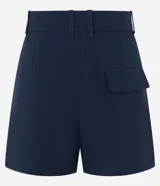 Short blanco de corte sastre, tiro alto, con pliegues frontales y trabillas en la cintura. Presenta solapas simulando bolsillos traseros.