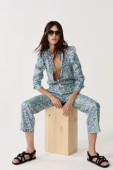 Pantalón de lino metalizado con estampado floral, tiro medio, piernas rectas y bolsillos laterales.