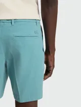 Shorts tipo chino de color turquesa, con corte entallado, cierre frontal de botón y cremallera, y trabillas para cinturón. Marca Boss, modelo H-Slice.