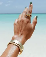 Pulsera tipo esclava abierta con diseño rústico y acabado irregular, fabricada en bronce y alpaca.