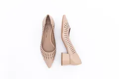 Zapato de cuero color nude, con taco cuadrado y punta fina. Presenta perforaciones decorativas en el empeine.