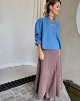 Pollera larga de denim color celeste claro, con corte en A y talle alto con elástico en la cintura.