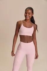 Top deportivo color rosado con tirantes finos, banda elástica y relleno extraíble. Confeccionado en tejido Sense Pro® con estampado de texto en relieve, ofrece compresión media, alta transpirabilidad y protección UV50+.