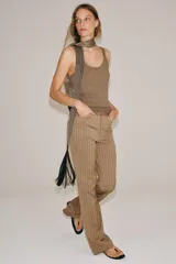 Pantalón flare de tiro medio, confeccionado en mezcla de viscosa y lino, con diseño de rayas verticales en tono beige. Cuenta con bolsillos delanteros y bajo acabado en línea evasé. Cierre frontal con cremallera, botón y ganchos metálicos.