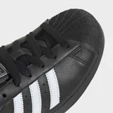 Championes Adidas Superstar II de diseño clásico, color negro con las icónicas tres bandas laterales en blanco. Presentan puntera de goma reforzada, suela de goma al tono y detalle de logo en el talón.