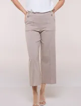 Pantalón crop blanco de corte recto con cintura ancha y botones decorativos laterales. Cuenta con bolsillos y pinzas frontales.
