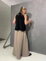 Falda larga beige de corte recto con tajo lateral, confeccionada en viscosa y elastano, con pretina lisa al frente y elástico en la parte posterior.