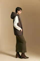 Chaleco acolchado de nylon color negro, con diseño capitoneado, capucha integrada y cierre frontal con tirador metálico.