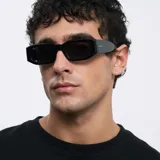 Lentes de sol negros con montura rectangular gruesa de acetato y lentes polarizadas con protección UV400. Diseño moderno con detalles biselados en el marco.