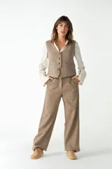 Pantalón de tiro alto y pierna recta color marrón, con bolsillos laterales y presillas para cinto.