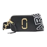 Cartera bandolera Marc Jacobs modelo The Snapshot, color tostado con herrajes dorados y logo frontal metálico. Incluye correa ajustable con diseño de cinta tejida y cierre superior.