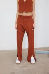 Pantalón de vestir color ladrillo, de corte recto con bolsillos laterales y tajo en el ruedo.