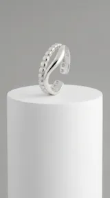 Anillo de plata 925 con diseño abierto y ajustable, compuesto por dos bandas: una con textura de pequeñas esferas y otra lisa y curva.