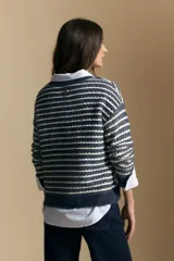 Sweater de punto con diseño de rayas horizontales en tonos tierra, con textura acanalada y cuello redondo. Presenta un corte relajado y mangas largas.