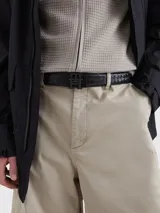 Cinturón reversible de cuero con hebilla metálica que presenta el monograma TH. El diseño cuenta con un lado de acabado liso y otro con acabado granulado.