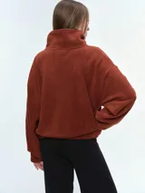 Campera de tela fleece doble, color negro, con cierre frontal completo, cuello alto y bolsillos laterales. Presenta puños y bajo elastizados para un ajuste cómodo.