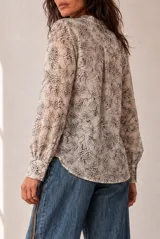 Camisa de manga larga color beige con estampado geométrico y floral en tonos marrones y naranjas, escote en V y botonadura frontal.