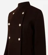 Campera de paño color marrón, con diseño estructurado de doble abotonadura con seis botones metálicos dorados. Presenta cuello alto, mangas largas y corte recto.
