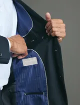 Traje de corte clásico compuesto por saco de dos botones y pantalón de vestir a juego. Diseño tradicional en color negro.